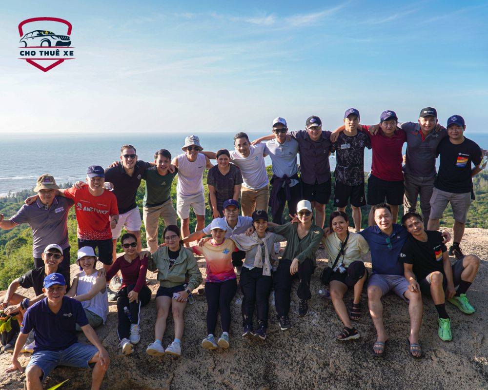 Nhóm người trekking giữa thiên nhiên tươi đẹp với biển xanh bao la ở phía xa và những thảm thực vật xanh mướt của khu bảo tồn Bình Châu - Phước Bửu