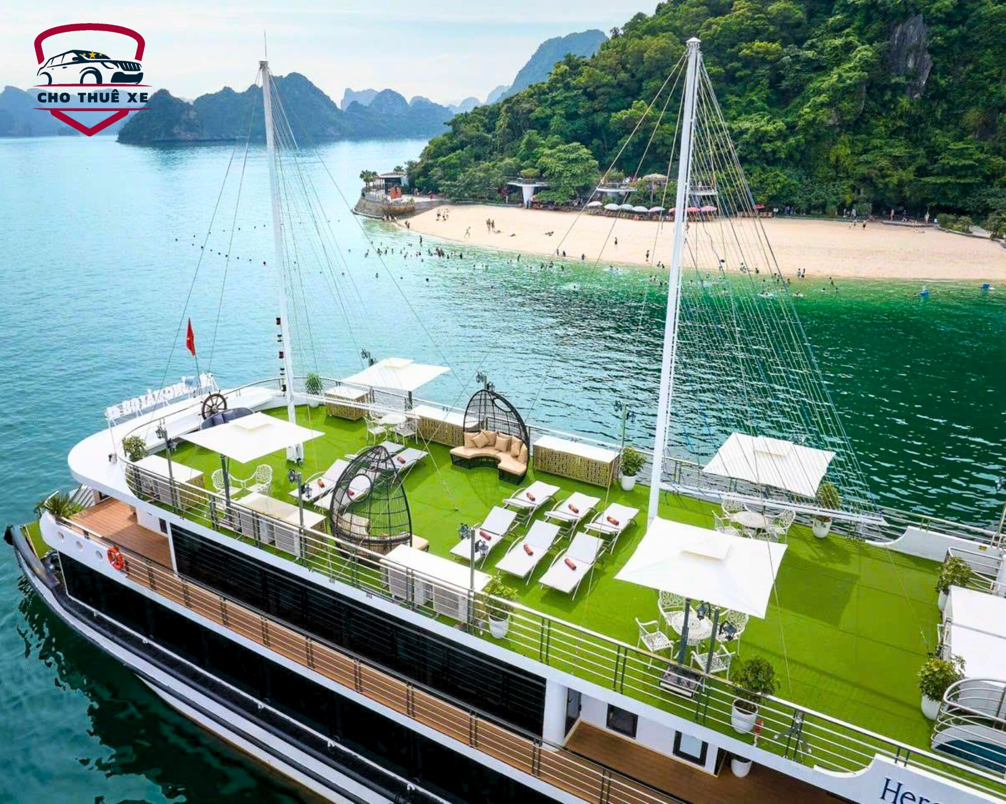 Du thuyền sang trọng neo đậu gần bãi biển cát trắng của Đảo Ti Tốp, Vịnh Hạ Long, với du khách đang tắm biển