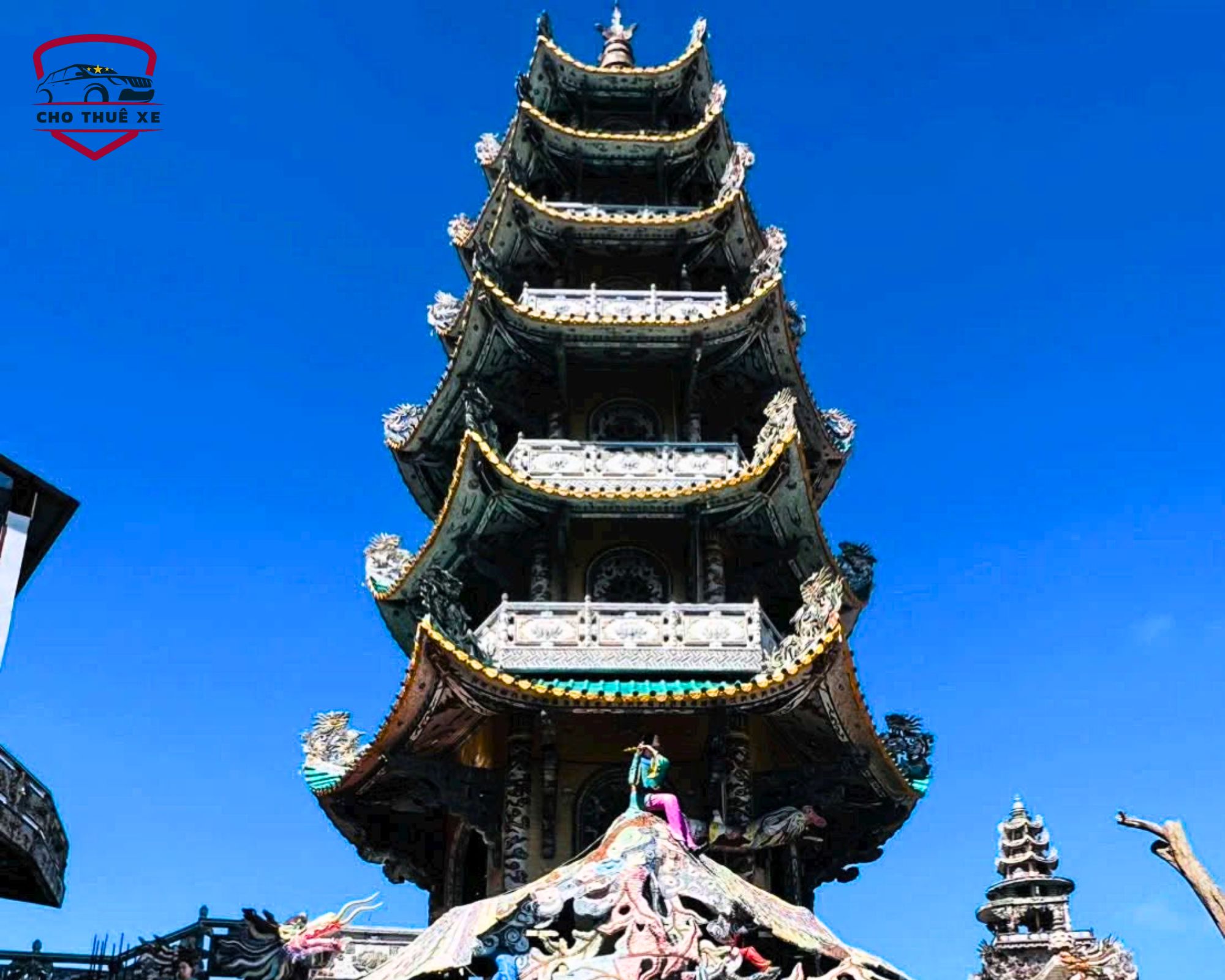 Chùa Linh Phước Đà Lạt với tháp chuông nhiều tầng sừng sững dưới bầu trời xanh, kiến trúc tinh xảo và hoa văn sặc sỡ trên mái