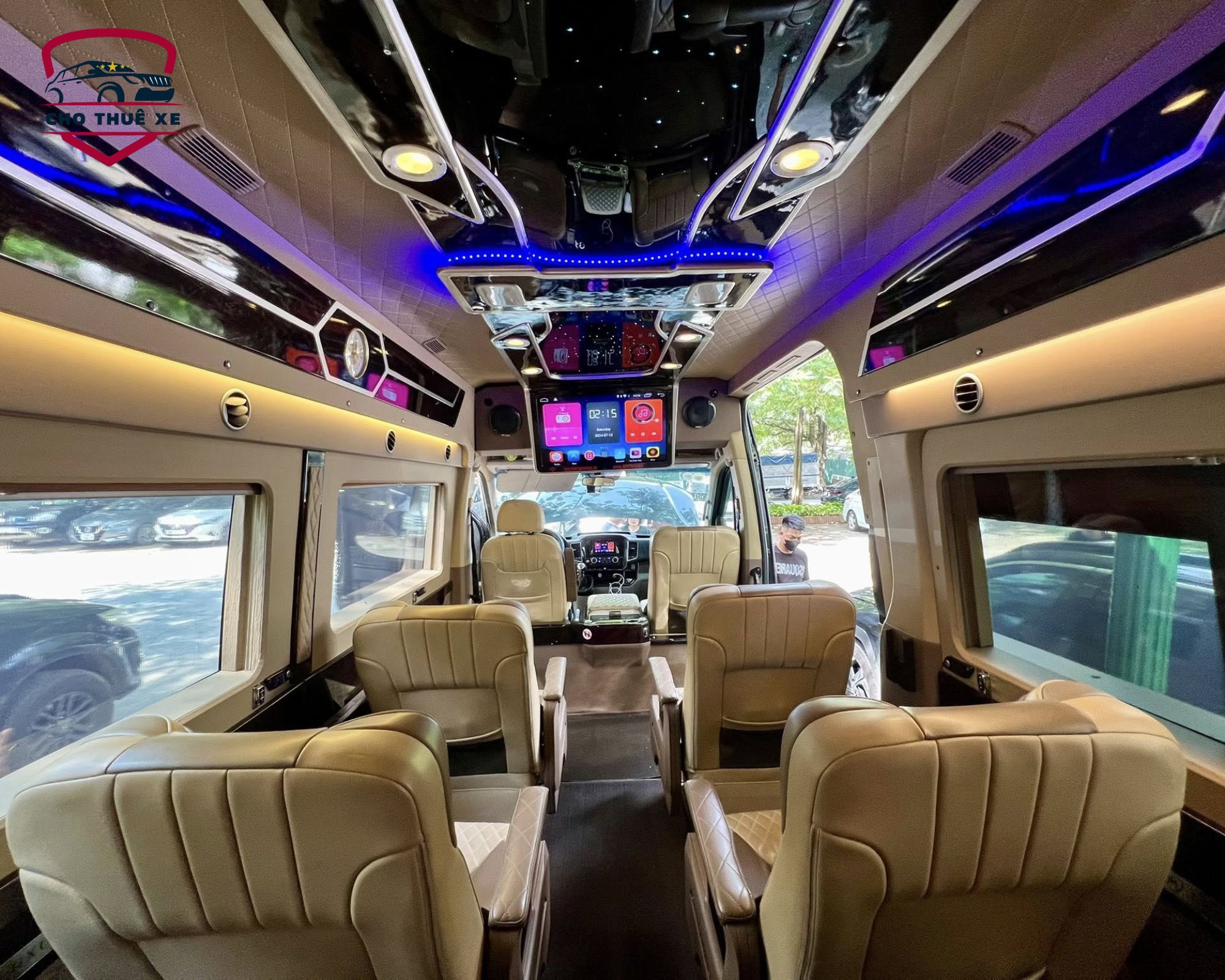 Hình ảnh cận cảnh nội thất xe limousine 12 chỗ, với các chi tiết sang trọng như ốp gỗ, chỗ để cốc và hệ thống điều khiển tiện lợi