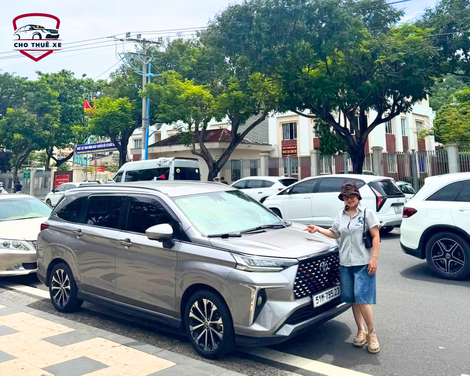 Khách nữ nhận xe thuê tự lái, chỉ tay vào đầu xe để đối chiếu tình trạng với hợp đồng
