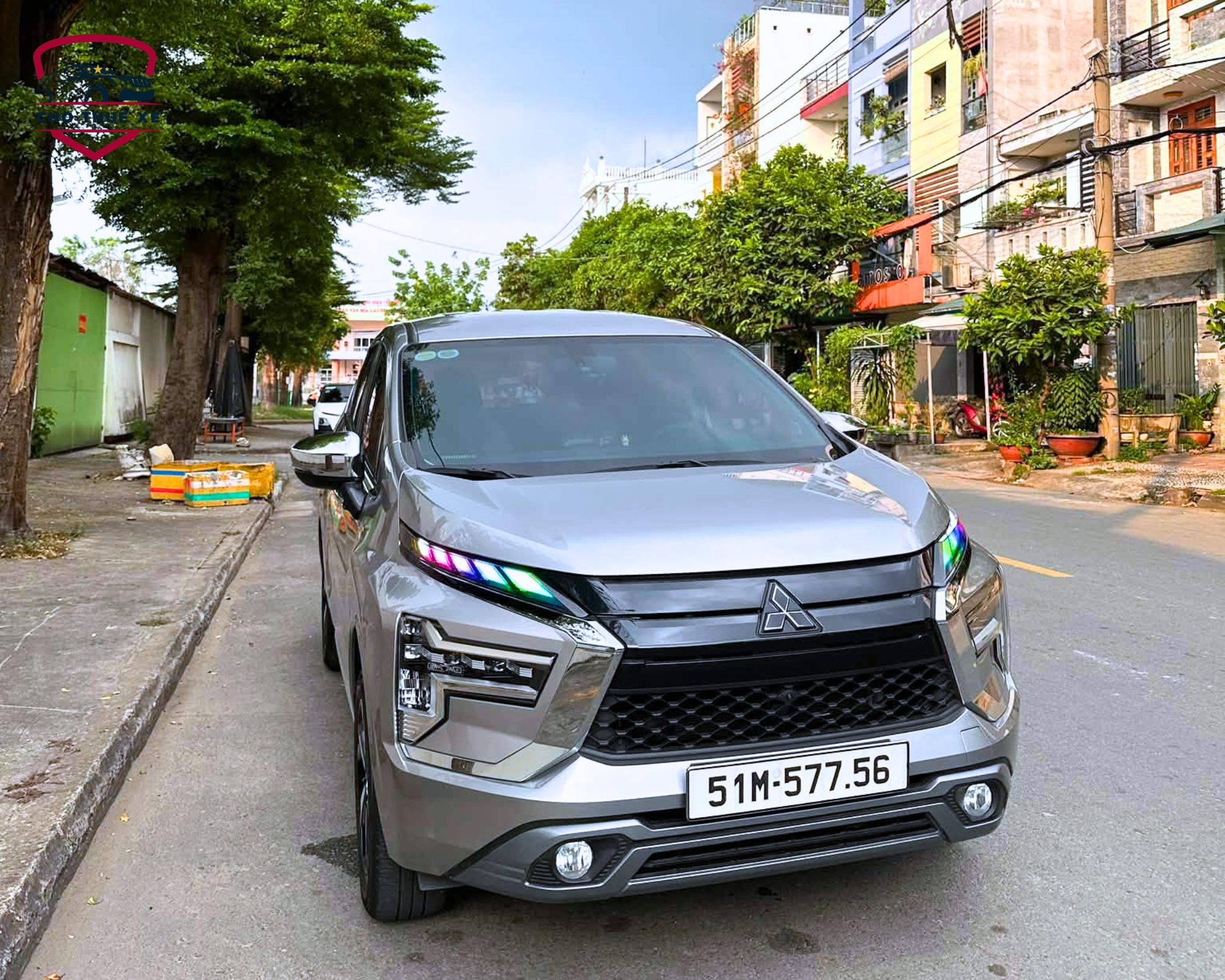 Xe Mitsubishi Xpander 7 chỗ màu bạc đỗ bên lề đường, đầu xe hướng về phía trước với lưới tản nhiệt nổi bật