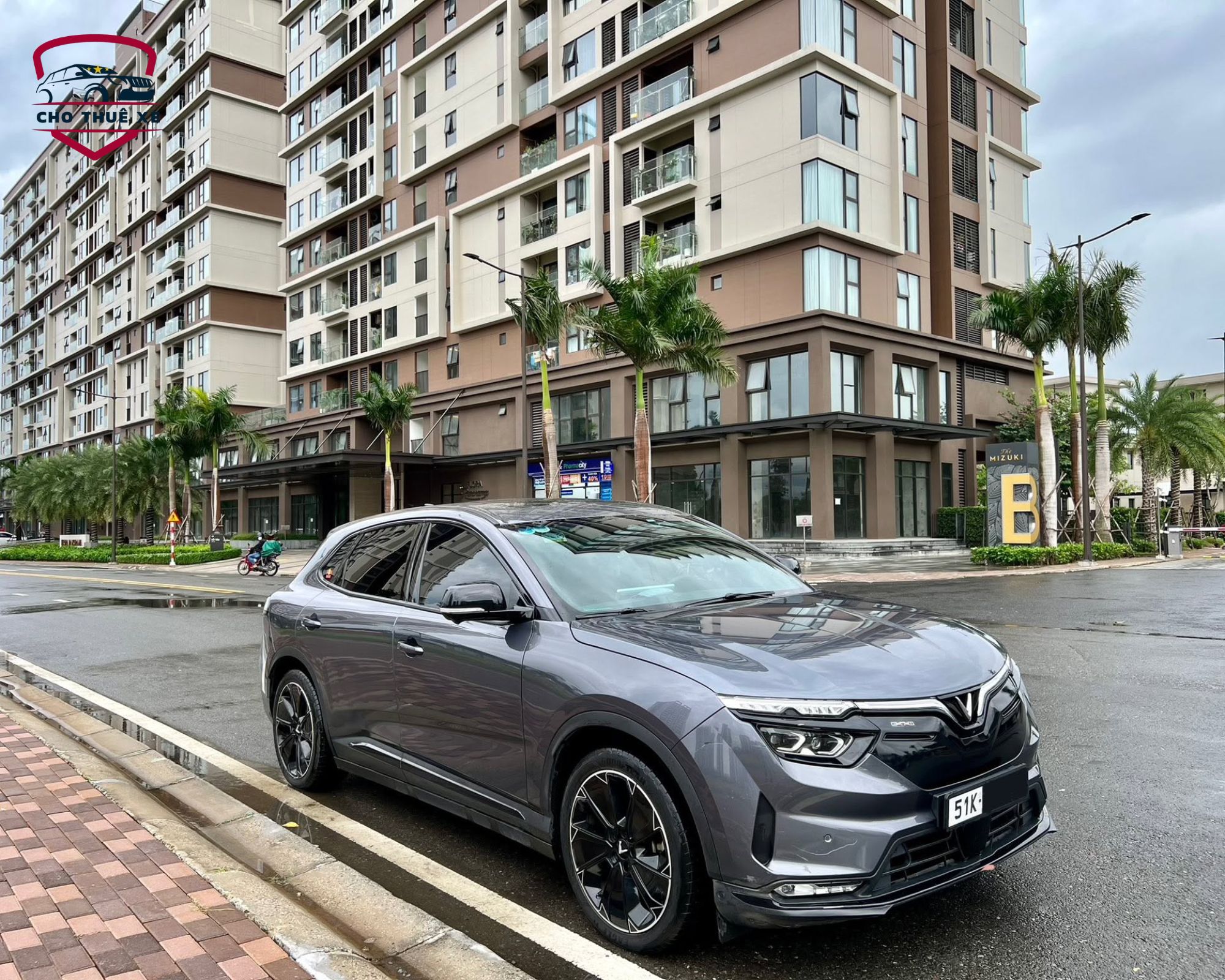 Xe ô tô 4 chỗ màu xám đậm đỗ ven đường thành phố