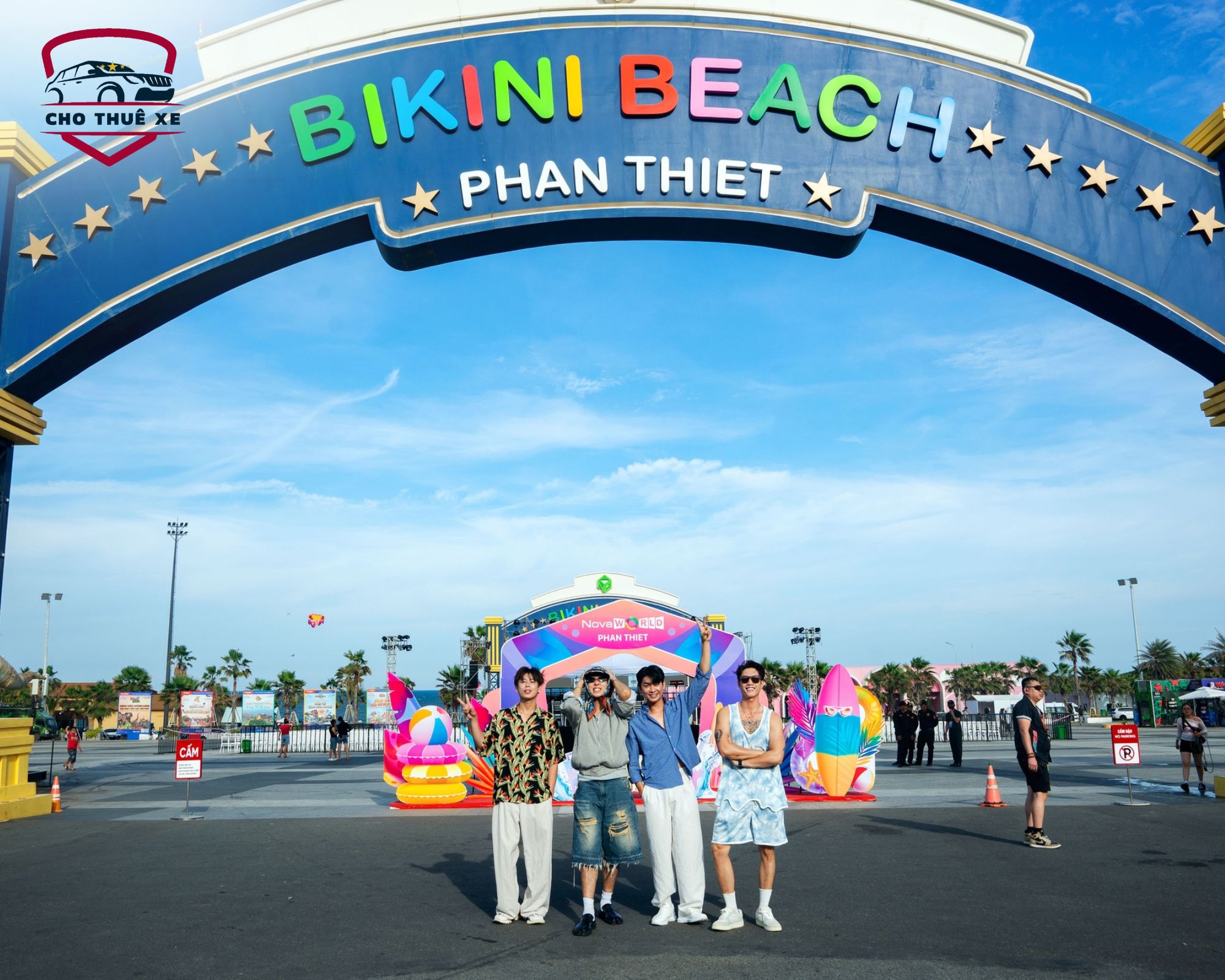 Nhóm bạn trẻ vui vẻ đứng chụp ảnh dưới cổng Bikini Beach Phan Thiết