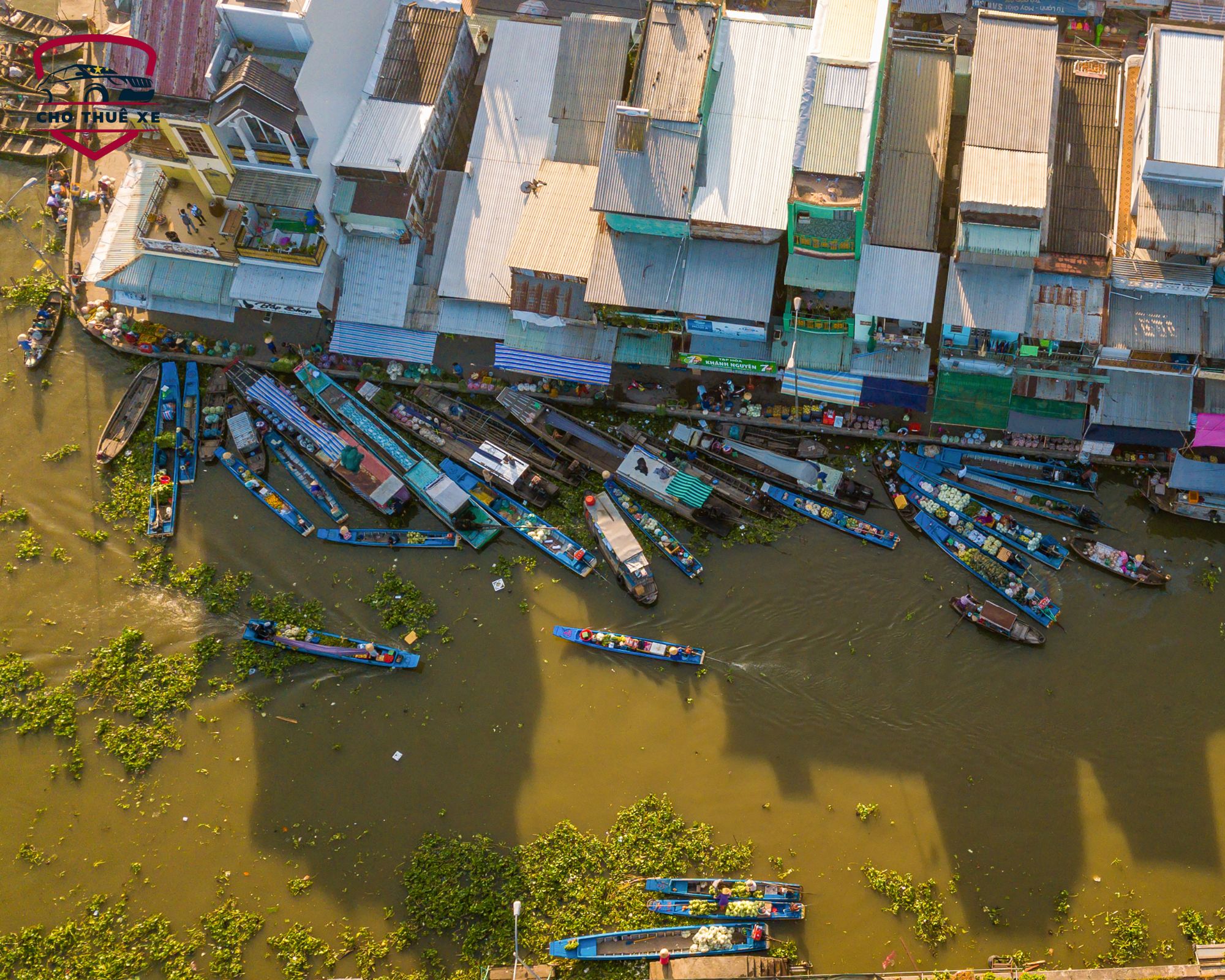 Chợ nổi Ngã Năm Sóc Trăng sầm uất nhìn từ trên cao, nhiều ghe thuyền buôn bán trái cây và hàng hóa trên dòng sông
