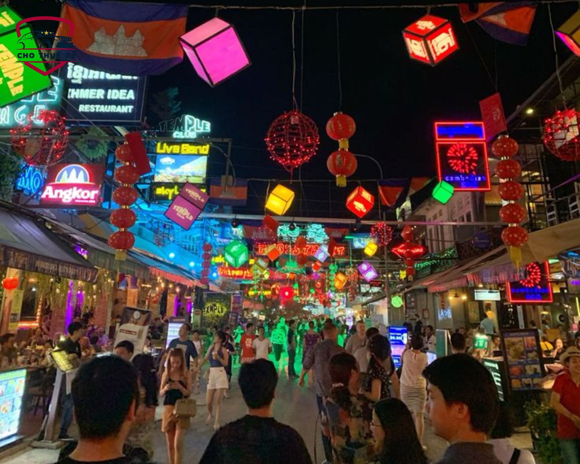 Phố đi bộ sôi động về đêm với hàng loạt biển hiệu neon rực rỡ và đèn lồng đỏ trang trí đặc trưng tại Campuchia