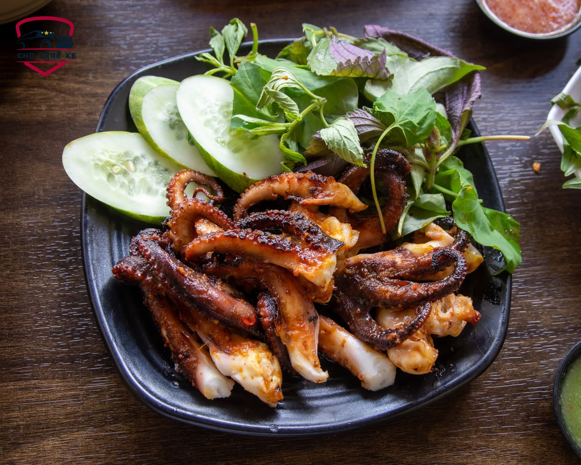 Đĩa mực nướng muối ớt hấp dẫn với râu mực cháy cạnh thơm lừng ăn kèm dưa chuột và rau thơm