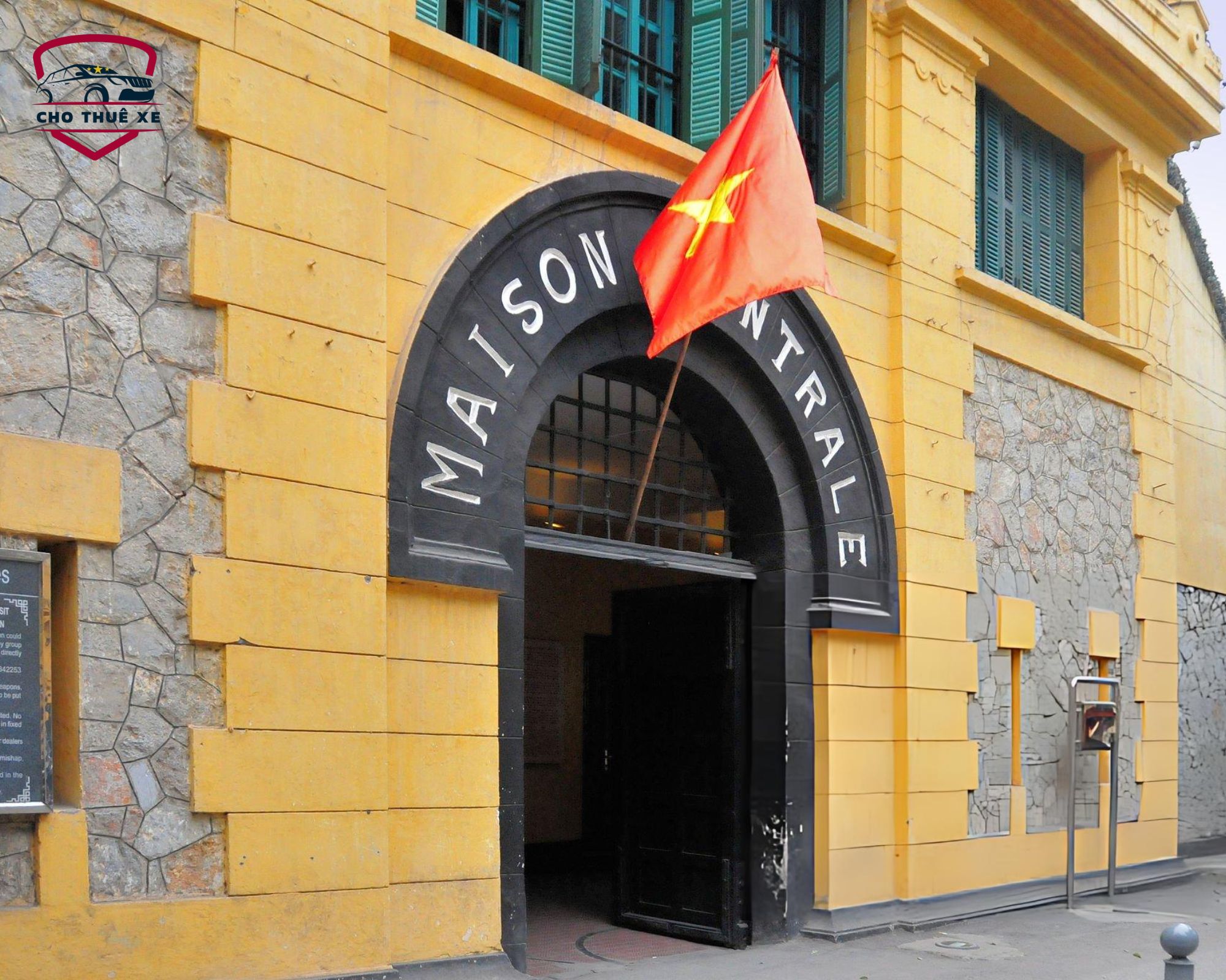 Quang cảnh cổng chính Nhà tù Hoả Lò với lá cờ đỏ sao vàng tung bay trên mái, di tích lịch sử cách mạng nổi bật trong hành trình khám phá thủ đô